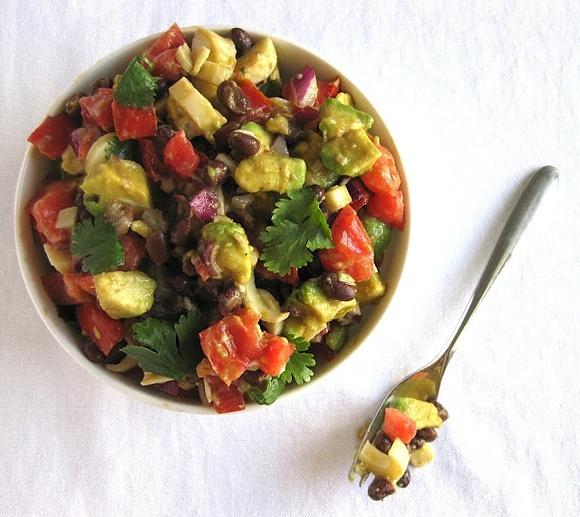 Hearty salad with black beans, tomatoes, avocado and hearts of palm