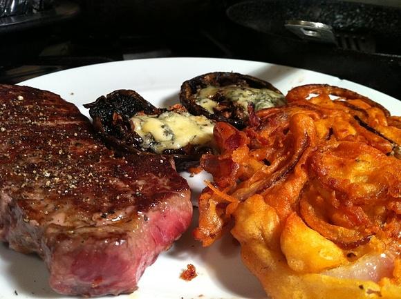 Sirloin steak with beer-battered red onion fritters and blue cheese stuffed portobello mushrooms