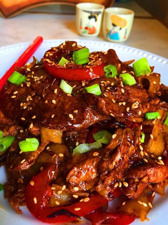Vegan spicy Szechuan orange beef with wide rice noodles